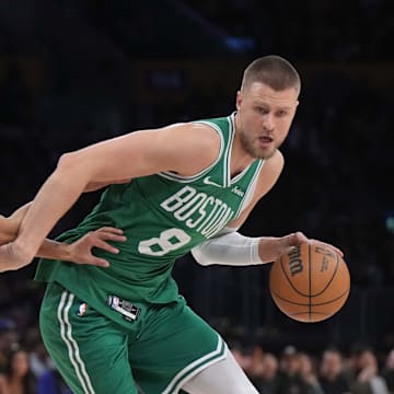 Jan 23, 2025; Los Angeles, California, USA; Boston Celtics center Kristaps Porzingis (8) dribbles the ball against Los Angeles Lakers guard Max Christie (12) in the first half at Crypto.com Arena. Mandatory Credit: Kirby Lee-Imagn Images