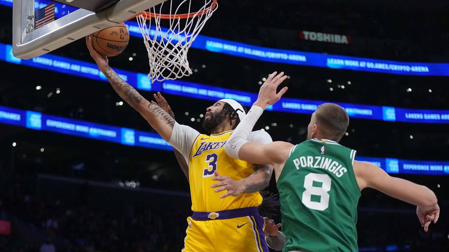 Los Angeles Lakers forward Anthony Davis shoots the ball against Boston Celtics center Kristaps Porziņģis .