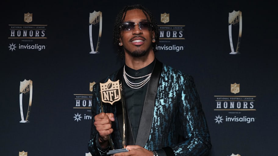Washington Commanders quarterback Jayden Daniels poses with the Offensive Rookie of the Year award. | Kirby Lee-Imagn Images