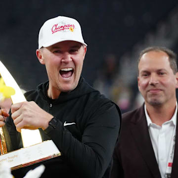 Dec 27, 2024; Las Vegas, NV, USA; Southern California Trojans head coach Lincoln Riley holds the championship trophy after the game against the Texas A&M Aggies at Allegiant Stadium. Mandatory Credit: Kirby Lee-Imagn Images