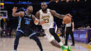 Dec 15, 2024; Los Angeles, California, USA; Los Angeles Lakers forward LeBron James (23) dribbles the ball against Memphis Grizzlies guard Marcus Smart (36) at Crypto.com Arena. Mandatory Credit: Kirby Lee-Imagn Images