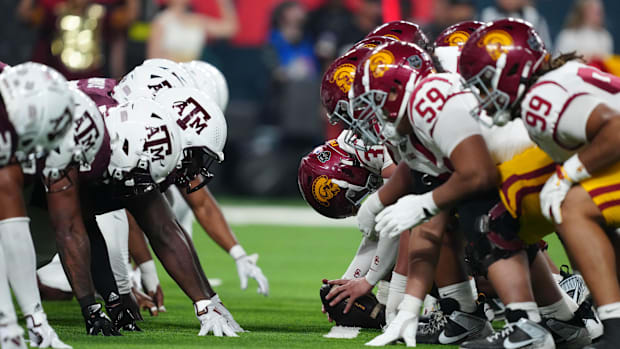 Helmets at the line fo scrimmage as DUPLICATE***Southern California Trojans long snapper Hank Pepper (31) snaps the ball agai