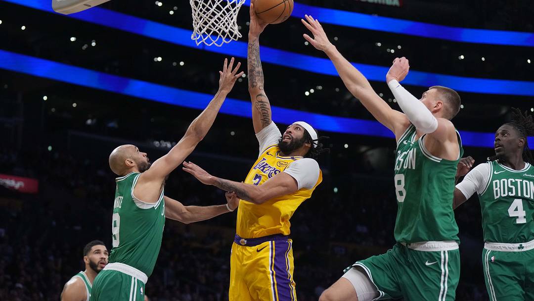 Jan 23, 2025; Los Angeles, California, USA: Los Angeles Lakers center Anthony Davis (3) shoots the ball against Boston Celtics center Kristaps Porzingis (8) and guard Derrick White (9) in the second half at the Crypto.com Arena. Mandatory Credit: Kirby Lee-Imagn Images