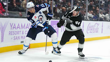 Nov 27, 2024; Los Angeles, California, USA; Winnipeg Jets center Mark Scheifele (55) and LA Kings defenseman Mikey Anderson (44) battle for the puck in the first period at Crypto.com Arena. Mandatory Credit: Kirby Lee-Imagn Images