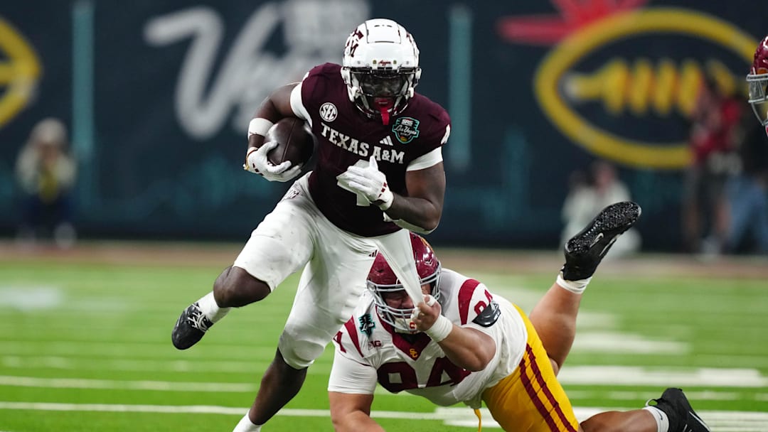 Dec 27, 2024; Las Vegas, NV, USA; Texas A&M Aggies wide receiver Micah Tease (4) carries the ball against Southern California Trojans defensive tackle Kobe Pepe (94) in the second half at Allegiant Stadium. Mandatory Credit: Kirby Lee-Imagn Images