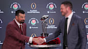 Dec 31, 2024; Los Angeles, California, USA; Ohio State Buckeyes head coach Ryan Day (left) and Oregon Ducks head coach Dan Lanning shake hands with the Leishman Trophy as a backdrop during the Rose Bowl head coaches press conference at Sheraton Grand LA. Mandatory Credit: Kirby Lee-Imagn Images