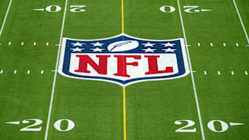 An overall view of the NFL shield logo at midfield on the Camping World Stadium flag football field. 