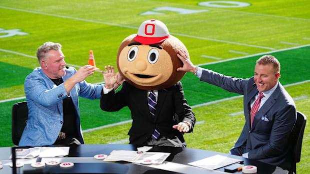 Jan 1, 2025; Pasadena, California, USA; Lee Corso (center) wears a Buckeyes mascot head  as Pat McAfee (left) and Kirk Herbst