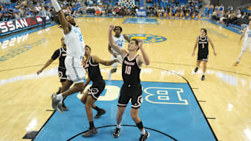 Nov 20, 2024; Los Angeles, California, USA; UCLA Bruins guard Sebastian Mack (12) shoots the ball against Idaho State Bengals forward Connor Hollenbeck (10) in the first half at Pauley Pavilion presented by Wescom. Mandatory Credit: Kirby Lee-Imagn Images