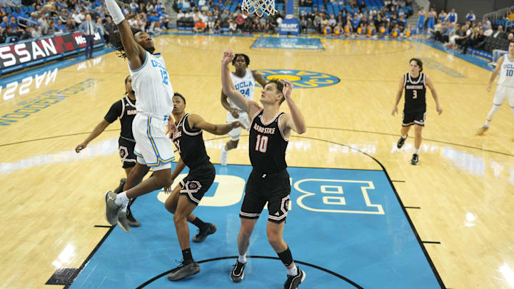 Nov 20, 2024; Los Angeles, California, USA; UCLA Bruins guard Sebastian Mack (12) shoots the ball against Idaho State Bengals forward Connor Hollenbeck (10) in the first half at Pauley Pavilion presented by Wescom. Mandatory Credit: Kirby Lee-Imagn Images