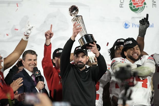 Ohio State Buckeyes head coach Ryan Day holds the Leishman Trophy after a CFP Quarterfinal against the Oregon Ducks at Rose B