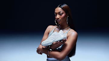 Angel Reese holds her first signature Reebok basketball shoe.