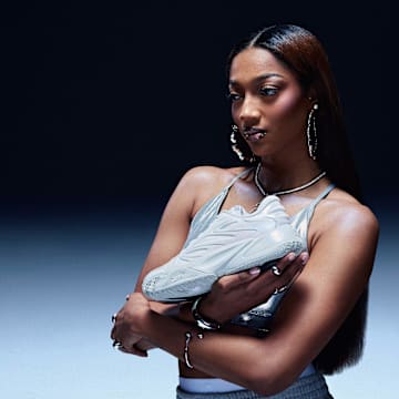 Angel Reese holds her first signature Reebok basketball shoe.