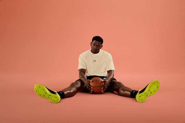 Anthony Edwards models his lime adidas sneakers.