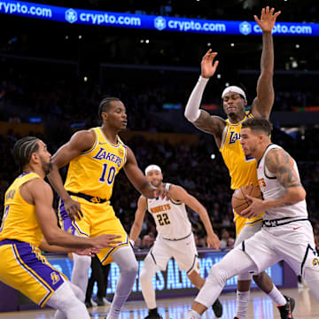 Mar 19, 2025; Los Angeles, California, USA;   Los Angeles Lakers center Christian Koloko (10), guard Gabe Vincent (7), forward Jarred Vanderbilt (2) and guard Luka Doncic (77) defend a drive by Denver Nuggets forward Michael Porter Jr. (1) in the second half at Crypto.com Arena. Mandatory Credit: Jayne Kamin-Oncea-Imagn Images