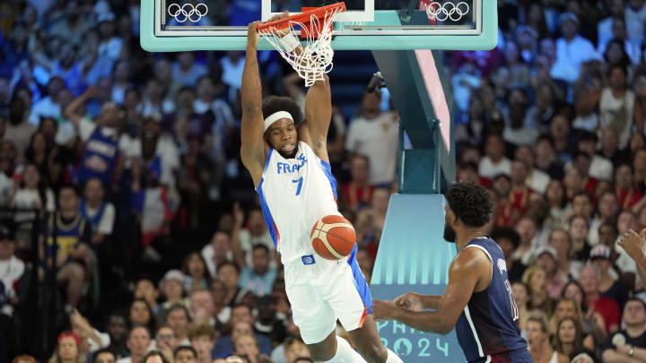 France power forward Guerschon Yabusele (7) dunks against United States centre Joel Embiid (11) in the first quarter in the men's basketball gold medal game during the Paris 2024 Olympic Summer Games at Accor Arena.