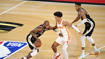 Milwaukee Bucks forward Khris Middleton (22) controls the ball against Atlanta Hawks forward Jalen Johnson (1) during the first quarter in a semifinal of the 2024 Emirates NBA Cup at T-Mobile Arena on Saturday.
