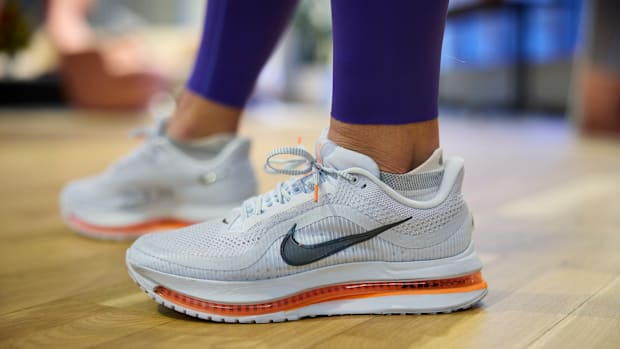 A woman wears white Nike shoes.