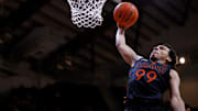 Jan 4, 2025; Blacksburg, Virginia, USA; Miami Hurricanes guard Divine Ugochukwu (99) dunks the ball during the second half against the Virginia Tech Hokies at Cassell Coliseum. Mandatory Credit: Peter Casey-Imagn Images