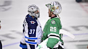 Winnipeg Jets goaltender Connor Hellebuyck shakes hands with Dallas Stars goaltender Jake Oettinger.