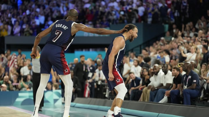 Aug 10, 2024; Paris, France; United States guard Stephen Curry (4) celebrates with forward Kevin Durant (7) in the men's basketball gold medal game during the Paris 2024 Olympic Summer Games at Accor Arena. 