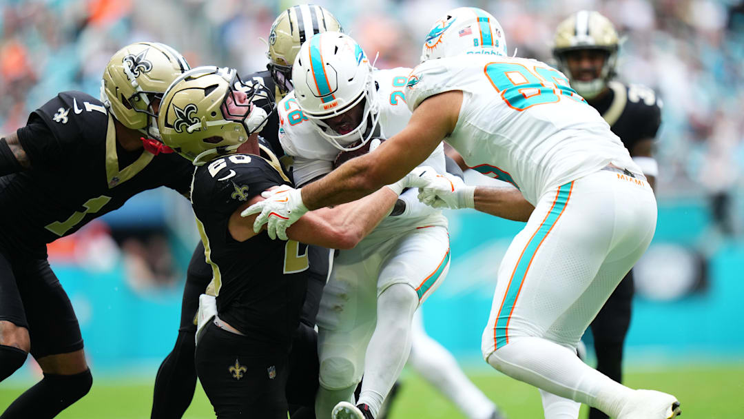 Miami Dolphins running back De'Von Achane (28) is tackled by New Orleans Saints linebacker Pete Werner (20) during the first half at Hard Rock Stadium.