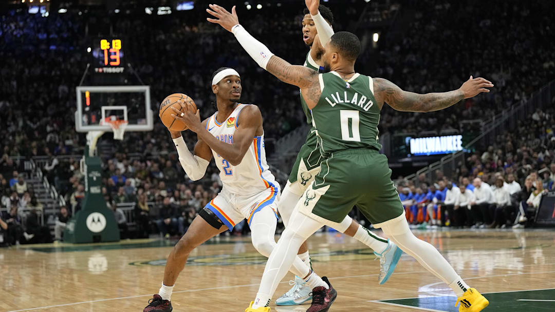Mar 24, 2024; Milwaukee, Wisconsin, USA;  Oklahoma City Thunder guard Shai Gilgeous-Alexander (2) looks to pass the ball under pressure from Milwaukee Bucks forward Giannis Antetokounmpo (34) and guard Damian Lillard (0) during the first quarter at Fiserv Forum. Mandatory Credit: Jeff Hanisch-Imagn Images