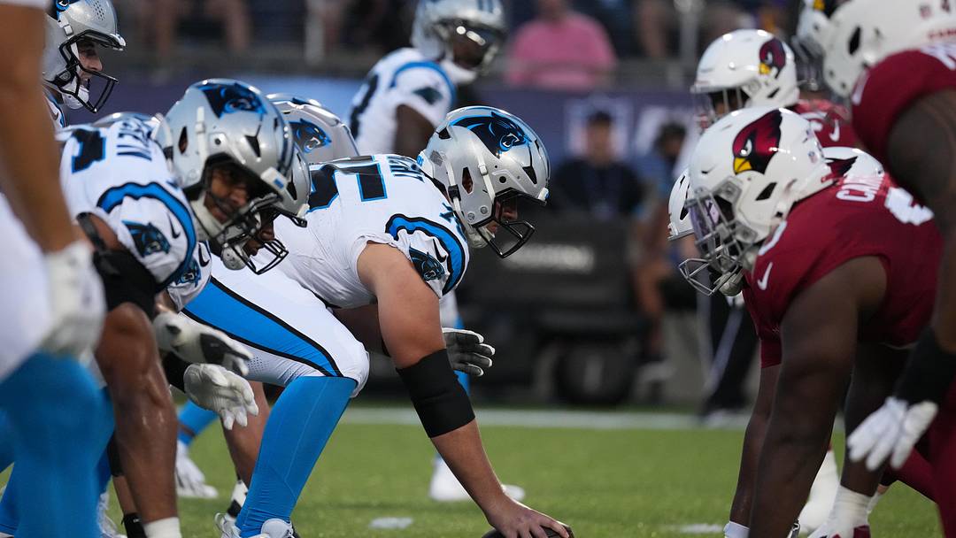 Aug 6, 2026; Canton, Ohio, USA; Helmets at the line of scrimmage as Carolina Panthers center Sam Hecht (75) snaps the ball against the Arizona Cardinals at Tom Benson Hall of Fame Stadium. Mandatory Credit: Kirby Lee-Imagn Images