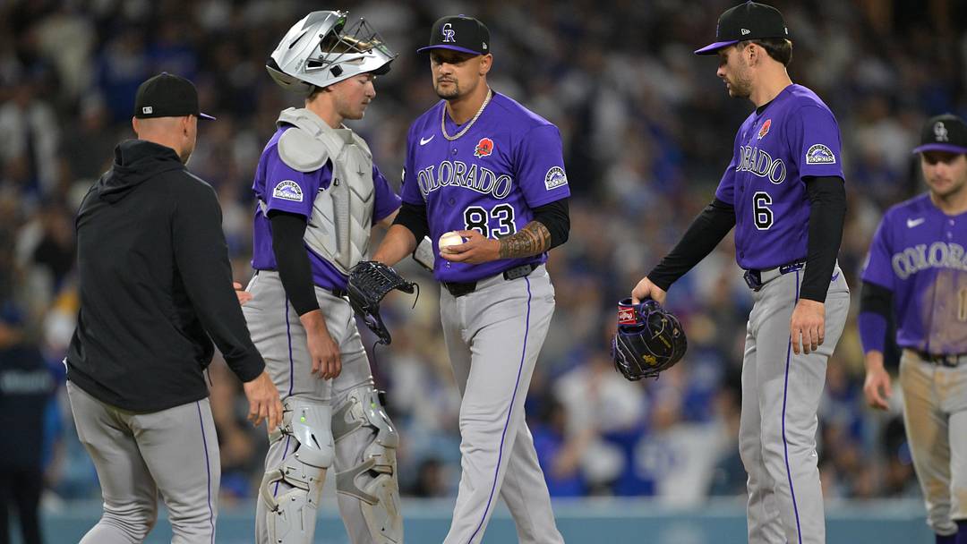 Colorado Rockies manager Warren Schaeffer (4) pulls relief pitcher Brennan Bernardino (83) in the seventh inning against the Los Angeles Dodgers.