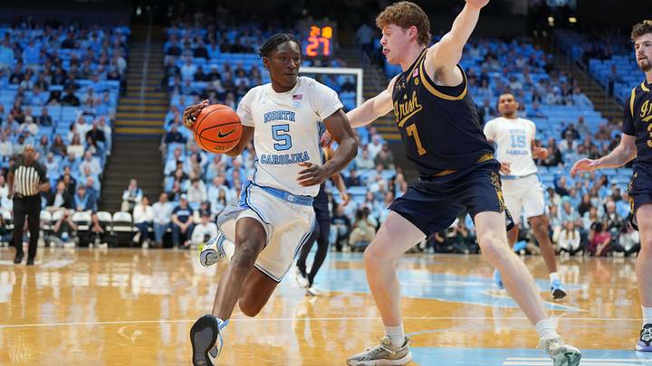 Jan 21, 2026; Chapel Hill, North Carolina, USA; North Carolina Tar Heels guard Isaiah Denis (5) with the ball as Notre Dame Fighting Irish forward Ryder Frost (7) defends in the second half at Dean E. Smith Center. Mandatory Credit: Bob Donnan-Imagn Images