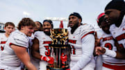 Nov 30, 2024; Lexington, Kentucky, USA; Louisville Cardinals defensive lineman Ramon Puryear (41) and Louisville Cardinals defensive back Jathan Hatch (31) hold up the Governor’s Cup trophy after winning against the Kentucky Wildcats at Kroger Field. Mandatory Credit: Jordan Prather-Imagn Images