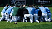 The Tulane Green Wave baseball program gathers in prayer moments before it takes the diamond