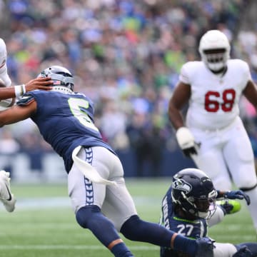 Oct 22, 2023; Seattle, Washington, USA; Arizona Cardinals quarterback Joshua Dobbs (9) breaks a tackle attempt by Seattle Seahawks safety Quandre Diggs (6) to later run the ball in for a touchdown during the first half at Lumen Field. Mandatory Credit: Steven Bisig-USA TODAY Sports