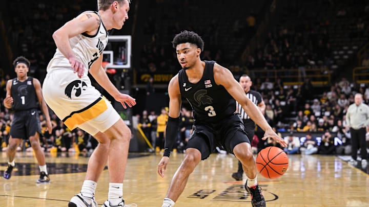 Mar 6, 2025; Iowa City, Iowa, USA; Michigan State Spartans guard Jaden Akins (3) controls the ball as Iowa Hawkeyes forward Payton Sandfort (20) defends during the first half at Carver-Hawkeye Arena. Mandatory Credit: Jeffrey Becker-Imagn Images