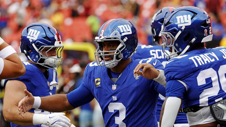 New York Giants quarterback Russell Wilson greets teammates before the game against the Washington Commanders.