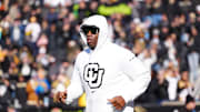 Nov 29, 2024; Boulder, Colorado, USA; Colorado Buffaloes head coach Deion Sanders runs onto the field before the game against the Oklahoma State Cowboys at Folsom Field. Mandatory Credit: Ron Chenoy-Imagn Images