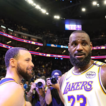Jan 25, 2025; San Francisco, California, USA; Los Angeles Lakers forward LeBron James (23) talks with Golden State Warriors guard Stephen Curry (left) and forward Draymond Green (right) after the game at Chase Center. Mandatory Credit: Darren Yamashita-Imagn Images