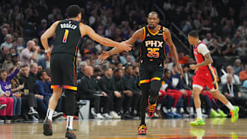Feb 28, 2025; Phoenix, Arizona, USA; Phoenix Suns forward Kevin Durant (35) and Phoenix Suns guard Devin Booker (1) slap hands against the New Orleans Pelicans during the first half at Footprint Center. Mandatory Credit: Joe Camporeale-Imagn Images