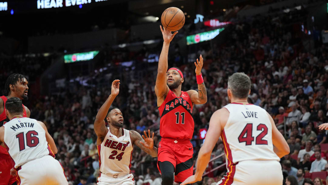 Apr 12, 2024; Miami, Florida, USA;  Toronto Raptors forward Bruce Brown (11) lobs a pass toward the basket as Miami Heat forward Haywood Highsmith (24) and forward Kevin Love (42) defend during the second half at Kaseya Center. Mandatory Credit: Jim Rassol-USA TODAY Sports