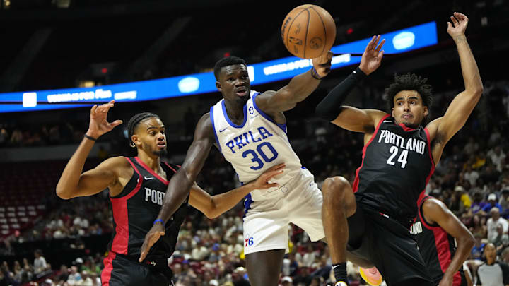 Jul 15, 2024; Las Vegas, NV, USA; Philadelphia 76ers forward/center Adem Bona (30) attempts to catch the rebound against Portland Trail Blazers forward Justin Minaya (24) and guard/forward Rayan Rupert during the second half at Thomas & Mack Center. Mandatory Credit: Lucas Peltier-Imagn Images