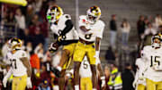 Nov 1, 2025; Chestnut Hill, Massachusetts, USA; Notre Dame safeties Tae Johnson (9) and Adon Shuler (8) leap and celebrate an interception in the fourth quarter against the Boston College Eagles at Alumni Stadium. Mandatory Credit: Edward Finan-Imagn Images
