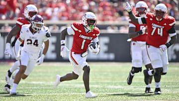 Aug 30, 2025; Louisville, Kentucky, USA; Louisville Cardinals running back Isaac Brown (1) runs the ball against Eastern Kentucky Colonels linebacker Kaden Smith (24) during the first half at L&N Federal Credit Union Stadium. Mandatory Credit: Jamie Rhodes-Imagn Images