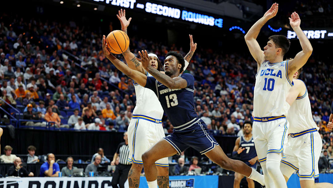 Mar 20, 2025; Lexington, KY, USA;  Utah State Aggies guard Deyton Albury (13) shoots the ball against UCLA Bruins guard Lazar Stefanovic (10) during the first half in the first round of the NCAA Tournament at Rupp Arena. Mandatory Credit: Jordan Prather-Imagn Images