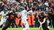 Dec 7, 2025; Cleveland, Ohio, USA; Tennessee Titans quarterback Cam Ward (1) throws a pass against Cleveland Browns defensive end Alex Wright (91) and linebacker Carson Schwesinger (49) during the second quarter at Huntington Bank Field. Mandatory Credit: Ken Blaze-Imagn Images