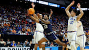 Mar 20, 2025; Lexington, KY, USA;  Utah State Aggies guard Deyton Albury (13) shoots the ball against UCLA Bruins guard Lazar Stefanovic (10) during the first half in the first round of the NCAA Tournament at Rupp Arena. Mandatory Credit: Jordan Prather-Imagn Images