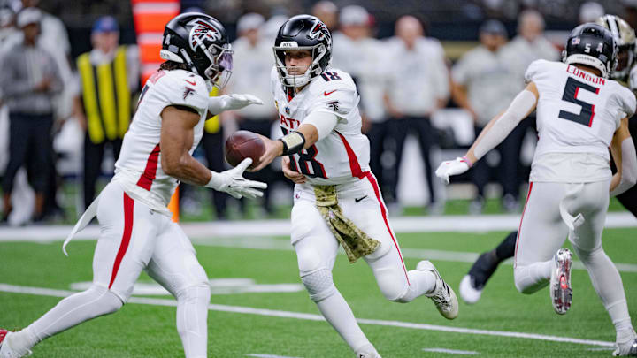 Nov 10, 2024; New Orleans, Louisiana, USA; Atlanta Falcons quarterback Kirk Cousins (18) hands off to Atlanta Falcons running back Bijan Robinson (7) during the first half against the New Orleans Saints at Caesars Superdome. Mandatory Credit: Matthew Hinton-Imagn Images Nov 10, 2024; New Orleans, Louisiana, USA; Atlanta Falcons quarterback Kirk Cousins (18) hands off to Atlanta Falcons running back Bijan Robinson (7) during the first half against the New Orleans Saints at Caesars Superdome. Mandatory Credit: Matthew Hinton-Imagn Images