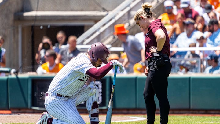 Jun 23, 2024; Omaha, NE, USA; Texas A&M Aggies third baseman Gavin Grahovac (9) kneels while talking with a staffer during the first inning against the Tennessee Volunteers at Charles Schwab Field Omaha. Mandatory Credit: Dylan Widger-Imagn Images