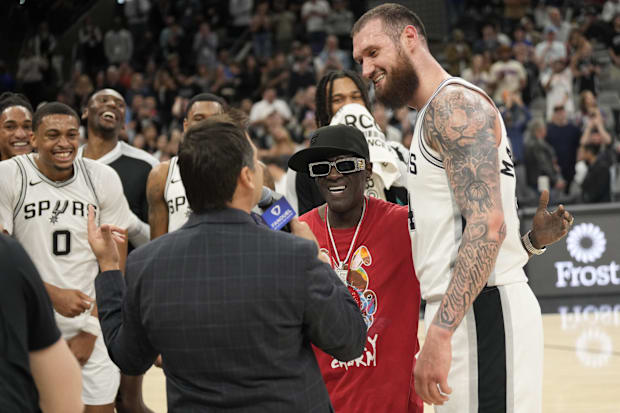 Rapper Flavor Flav congratulates San Antonio Spurs forward Sandro Mamukelashvili (54) after scoring thirty four points agains