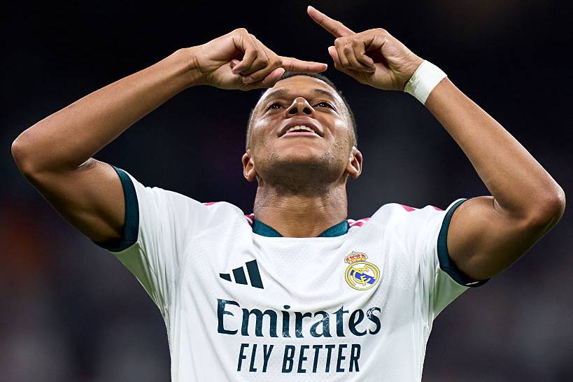 Kylian Mbappé pointing to the sky.