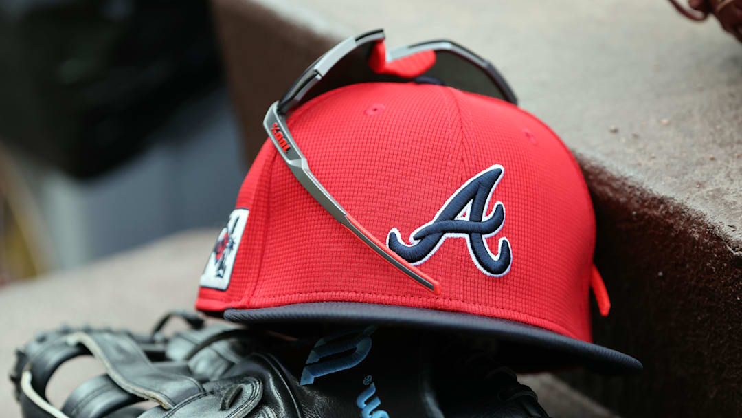 wMar 1, 2025; North Port, Florida, USA; A detail view of Atlanta Braves hat, sunglasses and glove in the dugout during the fifth inning at CoolToday Park. Mandatory Credit: Kim Klement Neitzel-Imagn Images